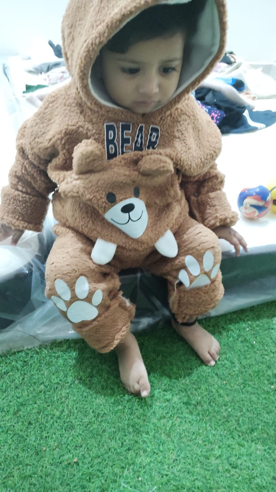 Child sitting on grass mat play area